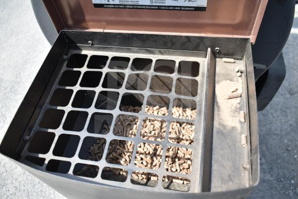 Pit Boss PB1500NX Savannah Pellet Grill hopper with pellets, visible label and commercial casters, indicating robust construction.