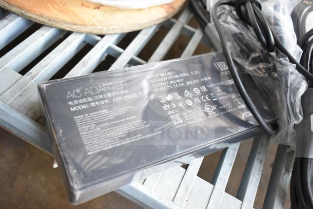 Black AC adapter, model ADP-280EB F, input 100-240V, output 20.0V, 3.2A. Includes cables on plastic-wrapped surface.