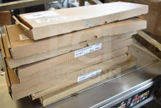 Stack of eight sealed brown boxes labeled "Scratch and Dent" keyboards, showing minor packaging wear.