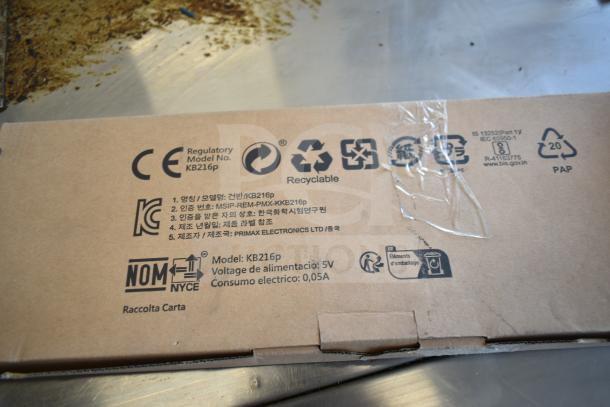 Cardboard box for keyboards model KB216p by Primax Electronics. Features voltage info, recyclable and regulatory symbols.