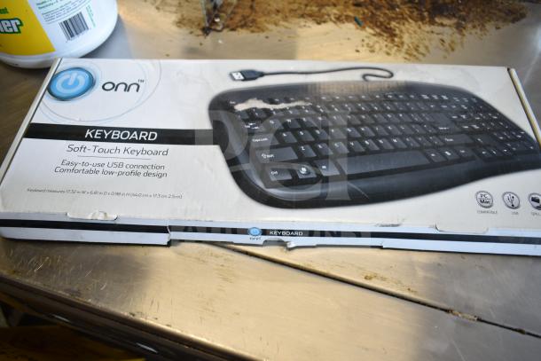 Boxed Onn soft-touch USB keyboard, brand new with visible box damage. Compatible with PC/Mac, low-profile design.