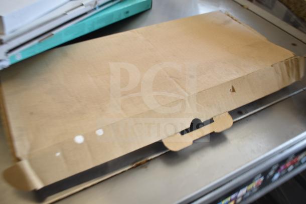 Cardboard box containing various branded keyboards, including Logitech and Onn, in new but scratch and dent condition.