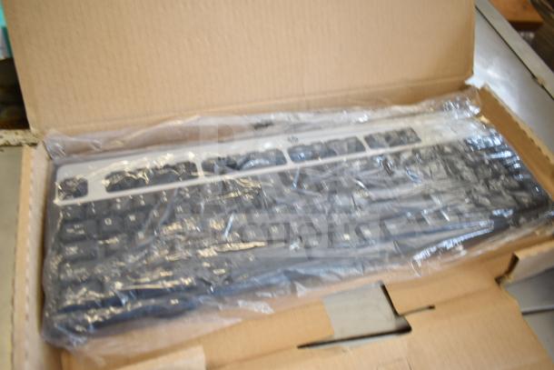 Four new scratch and dent keyboards, brands include Logitech and Onn; packaged in cardboard, partially visible through plastic wrap.