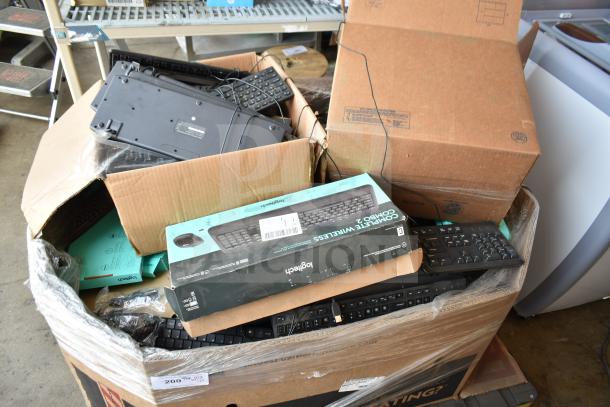 Pallet containing various keyboards, including boxed Logitech models, in mixed condition.