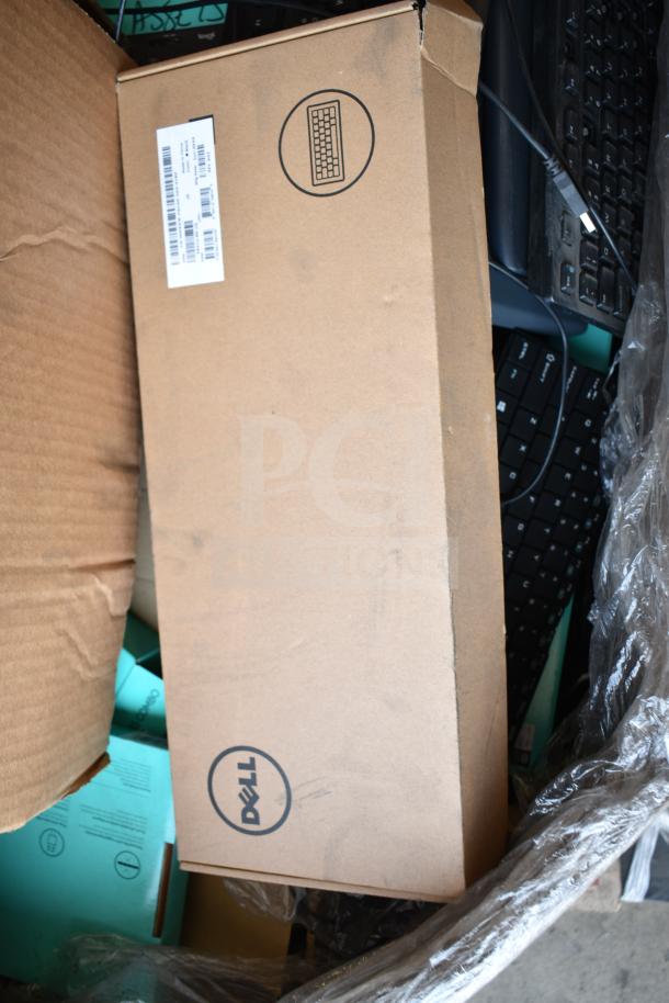 Pallet of various keyboards in Dell box, mixed brands and models visible, likely used, assorted conditions.