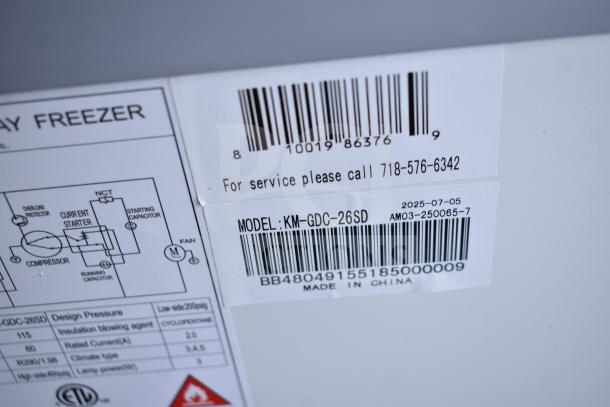 Barcode labels for KoolMore KM-GDC-26SD model; includes serial number and service contact. "Made in China" tag visible.