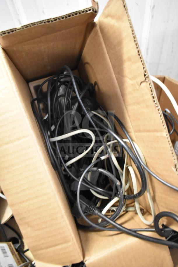 Pallet lot of GenSpeed Cat 5e riser cables in a box, mixed black and white, appears used, suitable for networking projects.