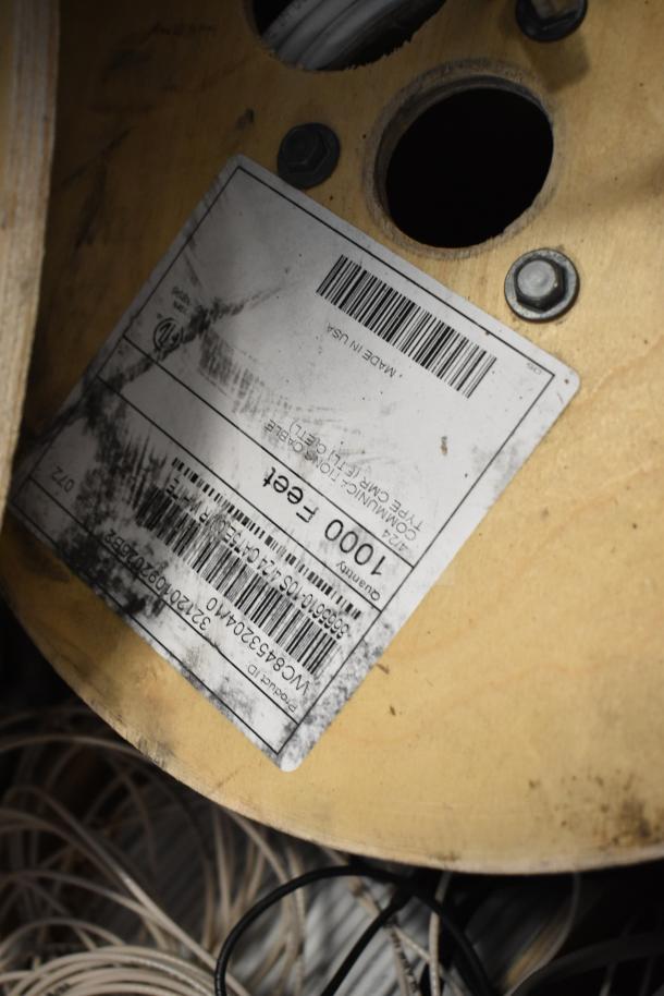 Pallet lot of GenSpeed Cat 5e riser cables, 1000 feet per reel, visible label detailing specifications, slightly worn condition.