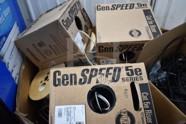 Pallet of GenSpeed Cat 5e Riser Cables in boxes, some opened, showing coils. Labels indicate brand and type.