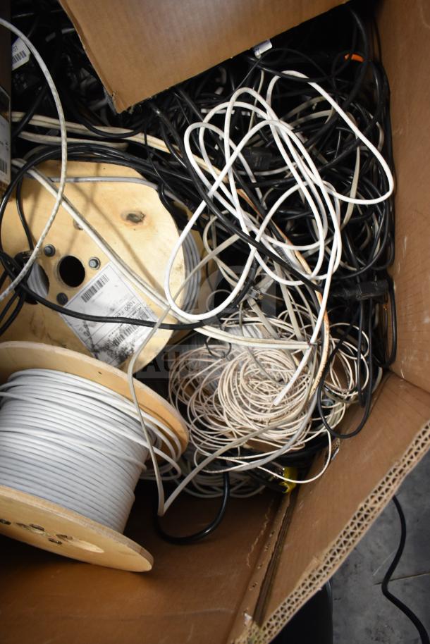 Pallet lot of GenSpeed Cat 5e riser cables, various lengths and colors, coiled on wooden spools, used condition.