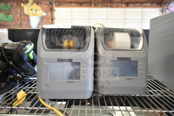 Two Zebra ZD621 Desktop Direct Thermal Barcode Printers on a shelf; display screens and buttons visible; used condition.