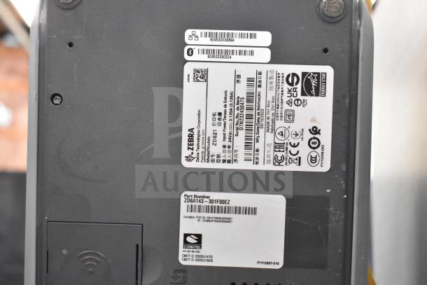 Zebra ZD621 barcode printer base showing labels with part number ZD6A143-301F00EZ, serial numbers, and compliance markings.