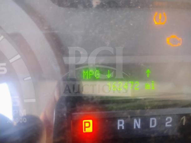 Dashboard of 2010 Ford E350 Cargo Van showing odometer reading 162,472 miles. Warning lights illuminated.