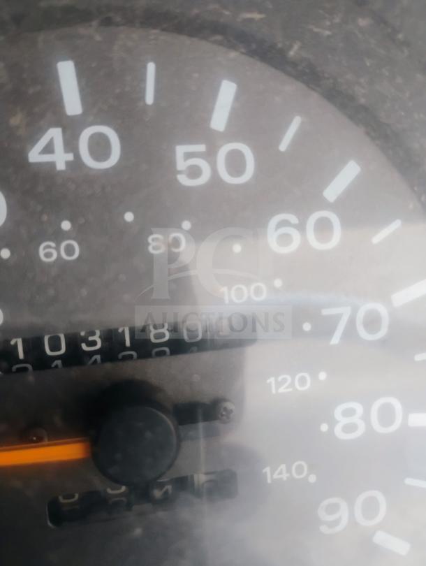 Close-up of the odometer reading 103,180 miles on a 1998 UD International Cab-Over Refrigerated Box Truck, indicating mileage.