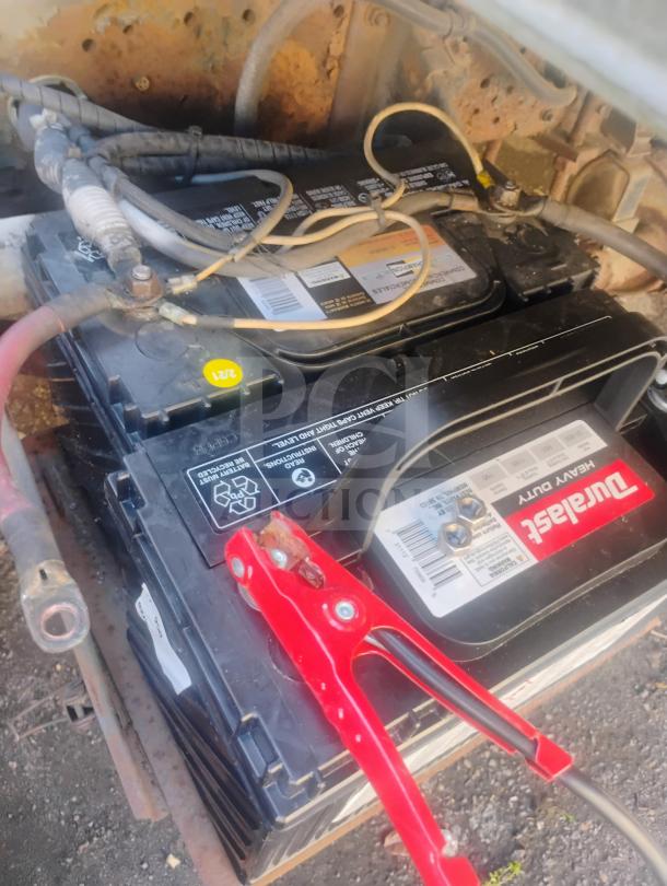 Battery setup in a 1998 UD International Cab-Over Refrigerated Box Truck showing Durastart Heavy Duty battery with clamp.