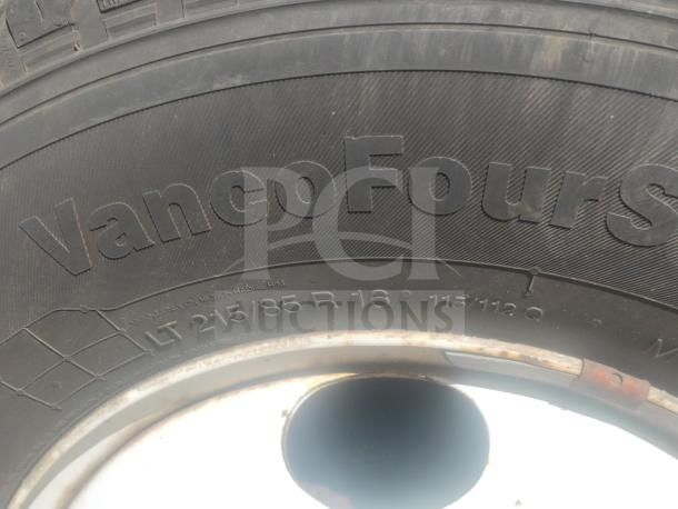 Close-up of a truck tire, branded "VancoFourS", showing tire size LT 215/85 R 16.