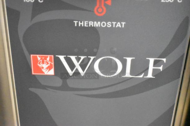 Wolf logo on the WC4GD-11D3 convection oven's stainless steel door, featuring thermostatic control panel.