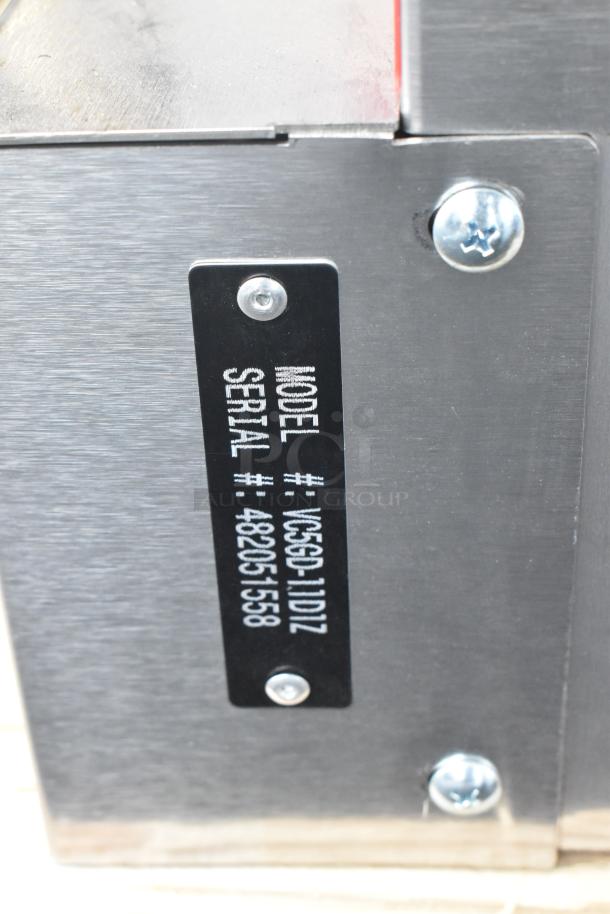 Close-up of a Vulcan VC5GD-11D1Z oven model and serial number label, indicating a stainless steel commercial convection oven.