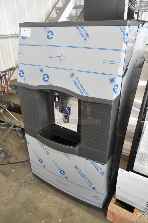 Stainless steel Manitowoc SPA312-161 commercial ice dispenser, 180 lb. capacity, touchless, brand new condition, with protective wrap.