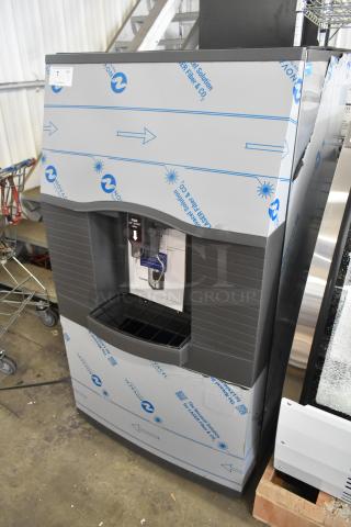 Stainless steel Manitowoc SPA312-161 commercial ice dispenser, 180 lb. capacity, touchless, brand new condition, with protective wrap.