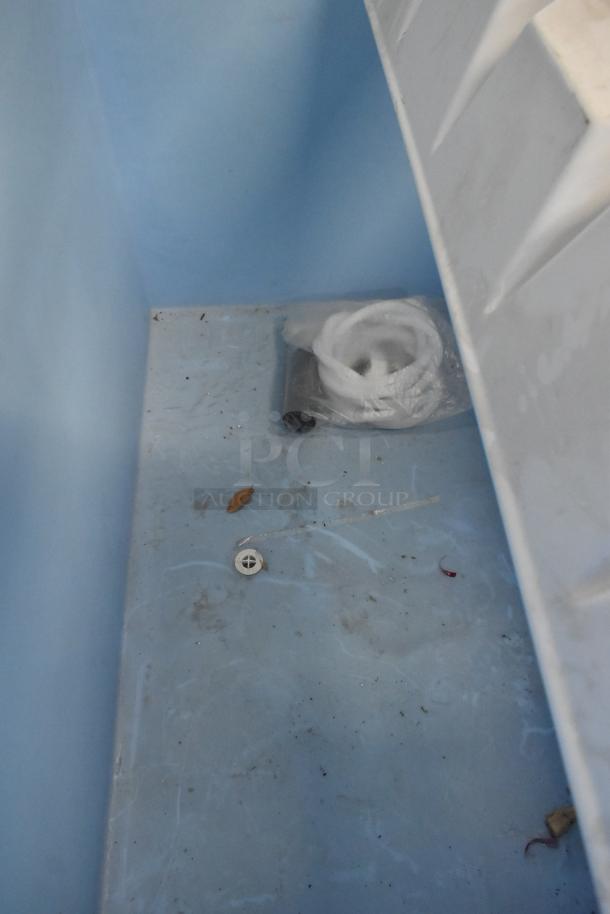 Interior of Hoshizaki B-900SF ice storage bin, showing some debris and packaged accessories, designed for 900 lb capacity.