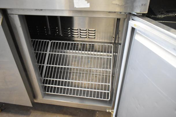Avantco 178SSWT48FHC stainless steel 2-door undercounter cooler, open to show interior shelving, on commercial casters.