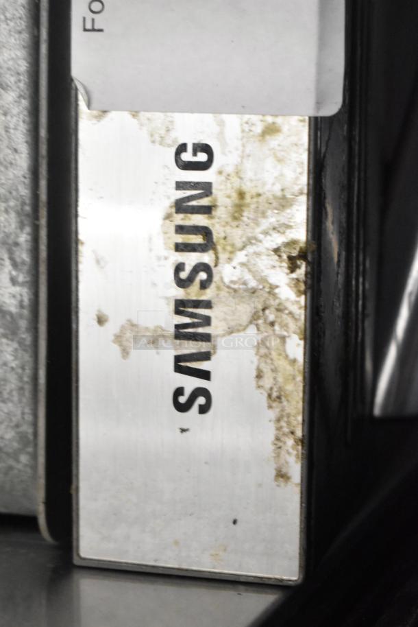 Samsung DW80M2020US stainless steel dishwasher, visible logo, some surface grime, undercounter model, 115V, 1 phase.