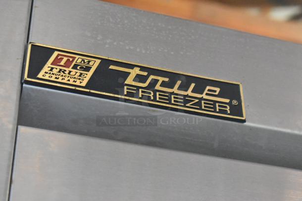 True T-72F stainless steel commercial 3-door reach-in freezer, features poly-coated racks, commercial casters, model label.