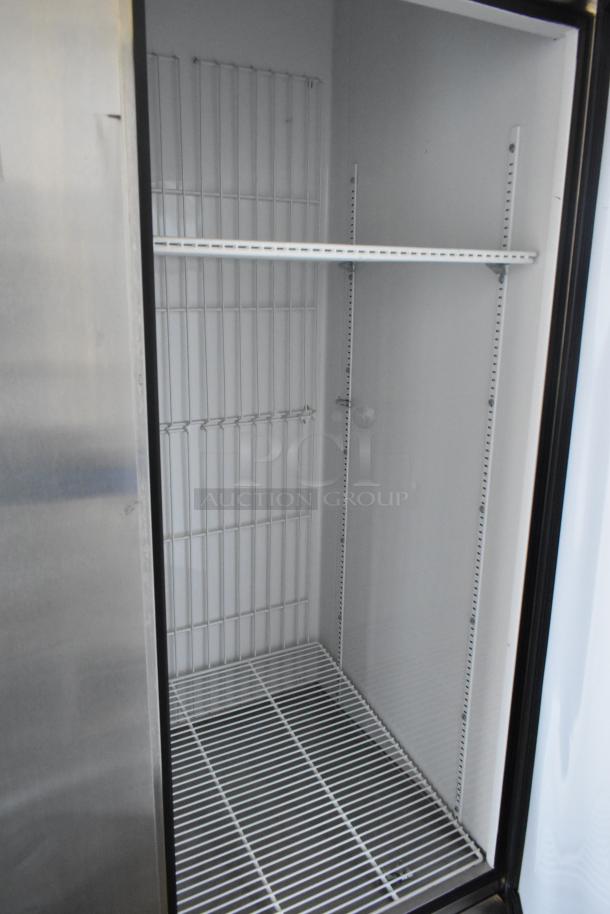 True T-72F stainless steel 3-door commercial freezer, interior view with poly-coated racks, on commercial casters, 115V.