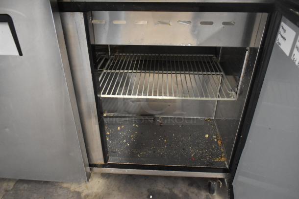 Turbo Air MST-72-30-N stainless steel prep table with shelving, on commercial casters. Shows interior condition, needs cleaning.