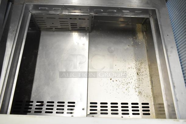 Turbo Air MST-72-30-N stainless steel commercial prep table, used, on commercial casters, 115 volts, 1 phase, interior view.