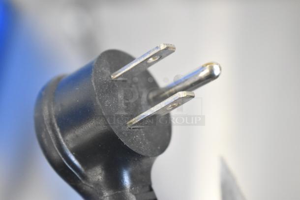 Close-up of a power plug for the Crane 5800-4 metal commercial bottled drink vending machine, showing standard prongs.