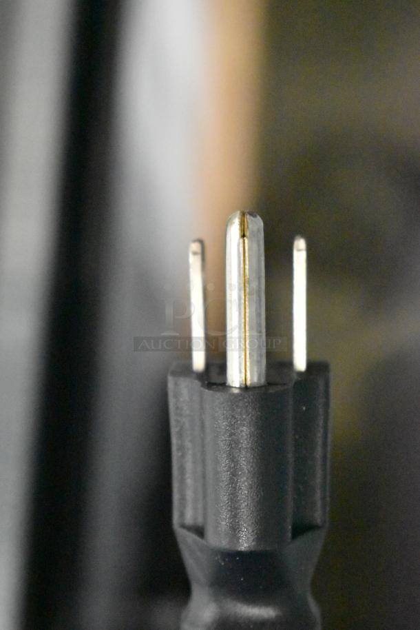 Close-up of a power plug for Avantco 178DLC82HCW refrigerated deli case, showing three metal prongs on black plastic casing.