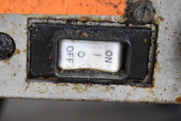 Close-up of a used on/off switch on a Pitco Frialator deep fat fryer, showing minor rust and wear around the edges.