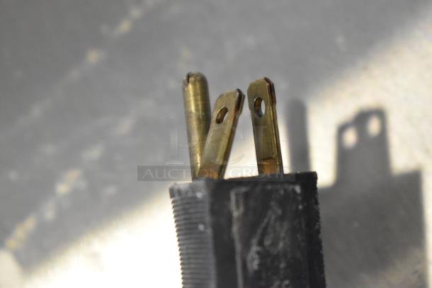 Close-up of a three-pronged electrical plug for a Bunn CWTF15-APS coffee machine.