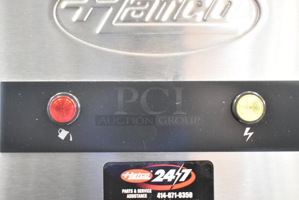 Brand new Hatco commercial water heater with metal finish, red and yellow indicator lights, and "Hatco 24/7" label.