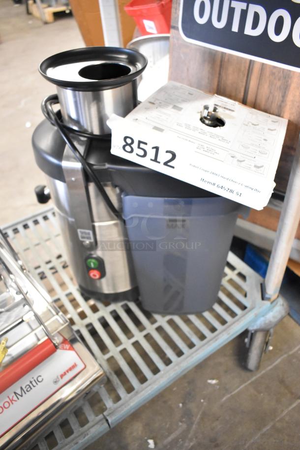 Brand new Robot Coupe J100 commercial juicer, stainless steel, continuous pulp ejection, 120V, brand tag visible.