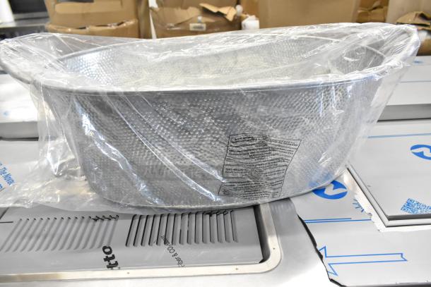 Brand new metal ice bucket, wrapped in plastic, with visible dents. Textured finish. Tags indicate scratch and dent condition.