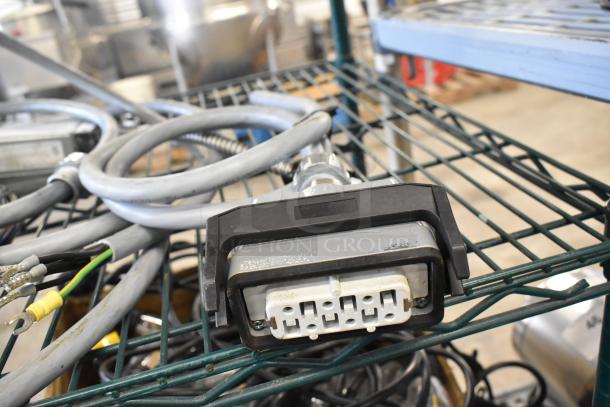 Lot of assorted wires and connectors on wire shelving, various sizes, used condition, ideal for electronics projects.