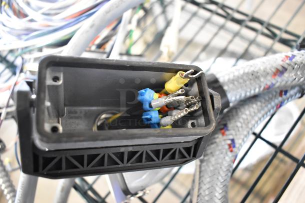 Lot of various wires and connectors in a black plastic box. Includes cables with colorful terminals. “Made in Germany” label visible.