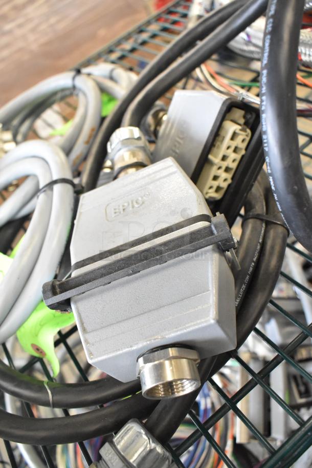 Various wires and components, including an EPIC connector, bundled on a metal cart. Suitable for electronics projects.