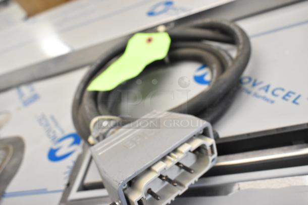 Bundle of cables including a large wire with a connector, marked with a green tag, suitable for various uses.