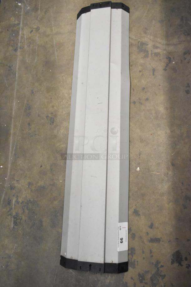 Brand new light fixture, scratch and dent condition, long rectangular shape, white finish with black end caps.