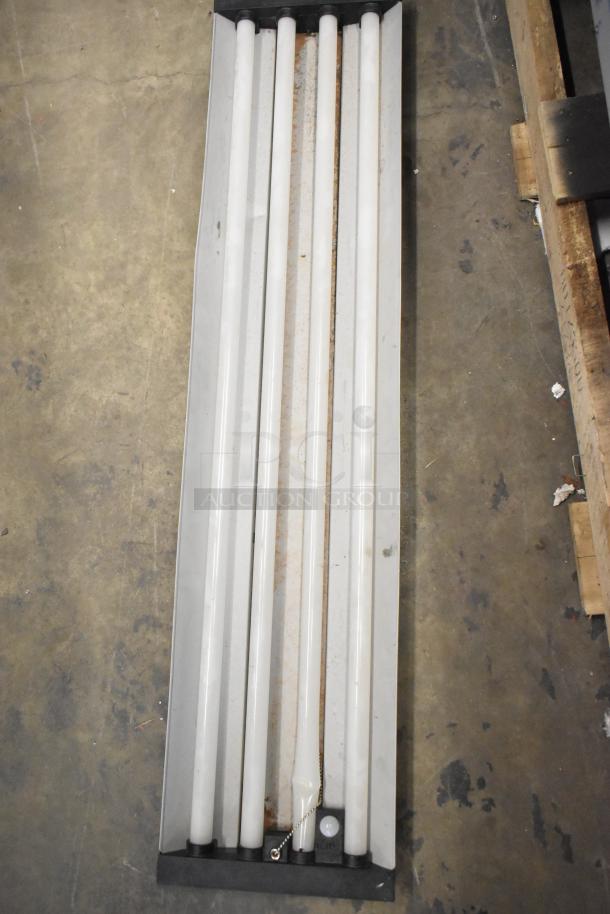 Brand new scratch and dent light fixture with five fluorescent tubes and visible chain pull switch, minor cosmetic damage.