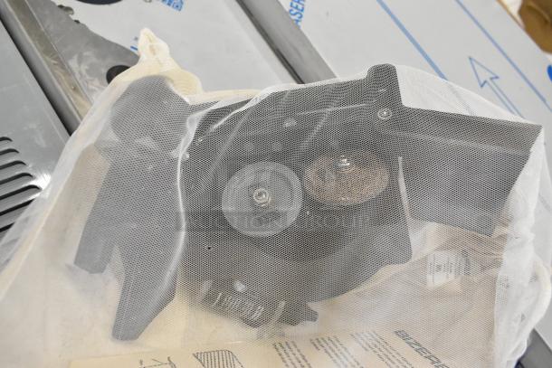 Brand new Bizerba meat slicer blade sharpener, scratch and dent condition, partially covered, includes manual and packaging.