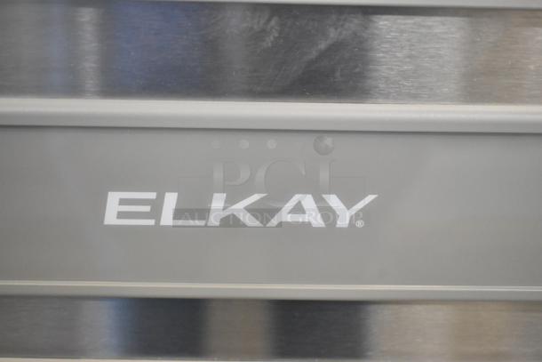 BRAND NEW Elkay water bottle filler with drip tray. Slight scratches visible. Model name "Elkay" displayed on front.