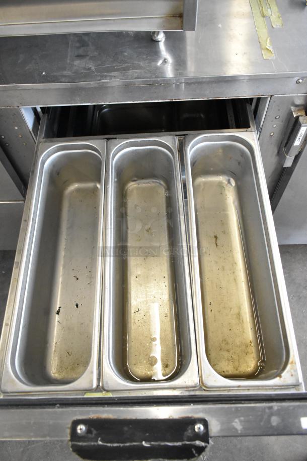 Beverage Air UCRD93A-4-23 undercounter cooler drawer, stainless steel, showing three compartments, on commercial casters.