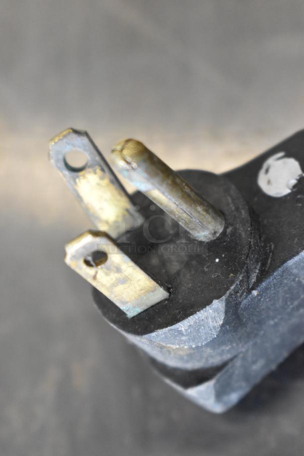 Close-up of a metal prong from a plug, showing signs of wear and discoloration.