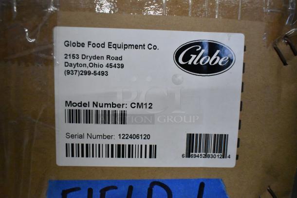 Alt text: "Globe CM12 stainless steel commercial meat chopper, new in box. Label shows model CM12, serial 122406120."