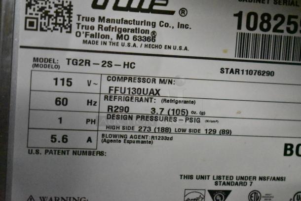 "Label of True TG2R-2S-HC Cooler showing model, voltage, refrigerant, and pressure details. Door requires reattachment."